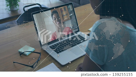 Talking man wearing light grey T-shirt on virtual call at wooden desk, with laptop and eyeglasses Talking man wearing light grey T-shirt on virtual call at wooden desk, with laptop and eyeglasses 139255155