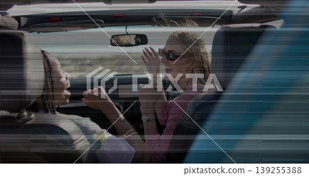 Rocking two friends raising hands driving convertible through desert, with sunglasses Rocking two friends raising hands driving convertible through desert, with sunglasses 139255388