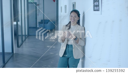 Business casual woman checking smartphone and glancing at smartwatch in office corridor, copy space 139255392