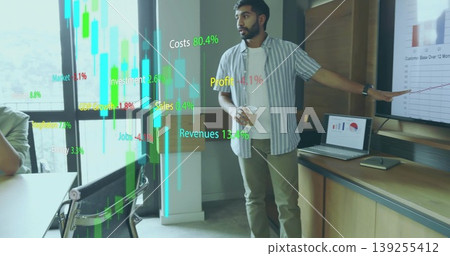 Pointing man presenting line chart in conference room, holding coffee cup with laptop data overlays Pointing man presenting line chart in conference room, holding coffee cup with laptop data overlays 139255412