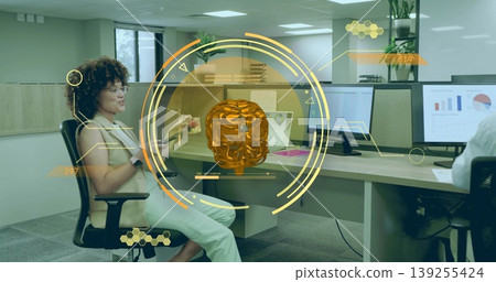 Demonstrating holographic orange skull, woman wearing blouse holding card in office with monitors 139255424