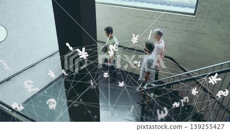 Descending team holding smartphone, tablet, laptop on office railing with floating currency symbols Descending team holding smartphone, tablet, laptop on office railing with floating currency symbols 139255427