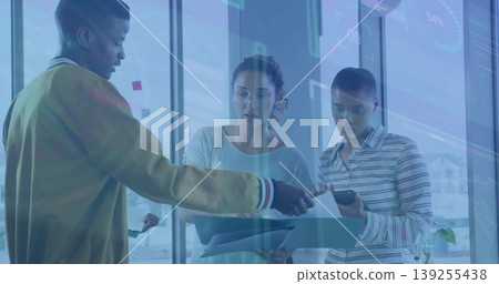 Colleagues in business attire analyzing data in glass office, with sticky notes, documents, tablet Colleagues in business attire analyzing data in glass office, with sticky notes, documents, tablet 139255438