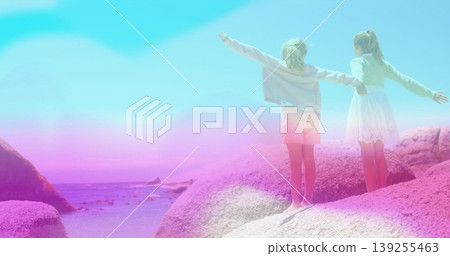 Girls wearing gray sweatshirt, shorts, white dress stretching arms on boulders by ocean, copy space Girls wearing gray sweatshirt, shorts, white dress stretching arms on boulders by ocean, copy space 139255463