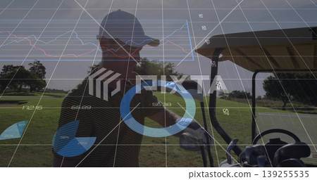 Golfer wearing striped polo and baseball cap retrieving club from cart on fairway, with sunglasses Golfer wearing striped polo and baseball cap retrieving club from cart on fairway, with sunglasses 139255535