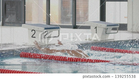 Diving male swimmer creating underwater splashes in lap pool at aquatic center, with red lane ropes Diving male swimmer creating underwater splashes in lap pool at aquatic center, with red lane ropes 139255538