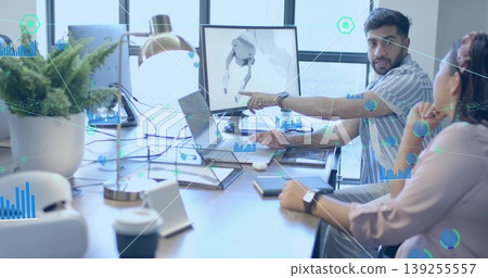 Pointing male engineer explaining robotic arm design on monitor in office workspace, with laptop Pointing male engineer explaining robotic arm design on monitor in office workspace, with laptop 139255557