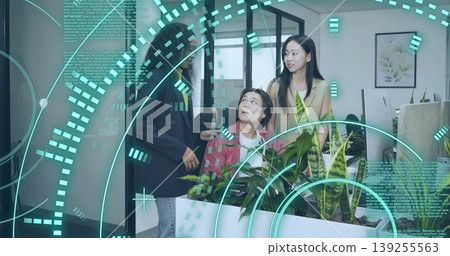 Three coworkers in blazers and sweater analyzing code on monitors in office, with digital overlay Three coworkers in blazers and sweater analyzing code on monitors in office, with digital overlay 139255563