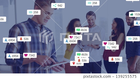 Collaborating professionals discussing social metrics on tablet and laptop in office with icons 139255575