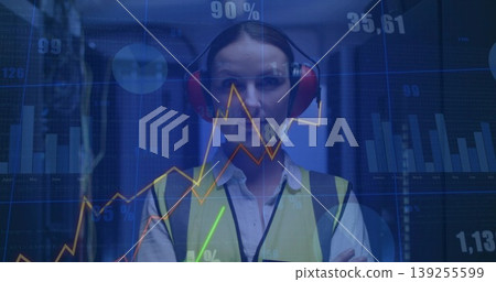 Technician wearing yellow vest red earmuffs inspecting racks in server room, floating data overlays Technician wearing yellow vest red earmuffs inspecting racks in server room, floating data overlays 139255599