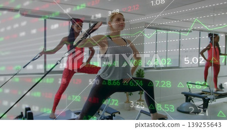 Lunging woman pulling resistance strap on reformer in Pilates studio with stock market overlay Lunging woman pulling resistance strap on reformer in Pilates studio with stock market overlay 139255643