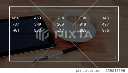 Displaying black tablet showing numeric overlay on wood table, coffee cup, saucer, pen, copy space Displaying black tablet showing numeric overlay on wood table, coffee cup, saucer, pen, copy space 139255696