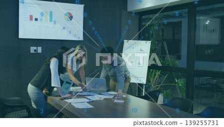 Three professionals reviewing sales data in conference room, with laptop and display screen Three professionals reviewing sales data in conference room, with laptop and display screen 139255731