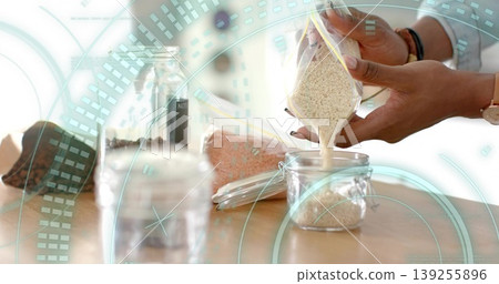 Pouring grains from plastic bag into jar by woman's hands on countertop in kitchen, copy space Pouring grains from plastic bag into jar by woman's hands on countertop in kitchen, copy space 139255896