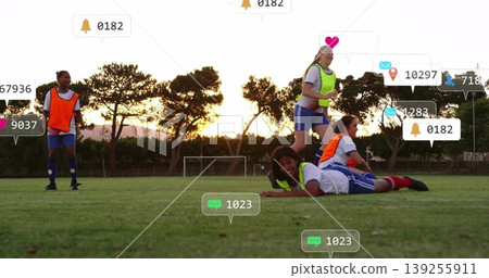 Sliding female soccer player wearing bib gliding across pitch at sunset, with notification icons Sliding female soccer player wearing bib gliding across pitch at sunset, with notification icons 139255911