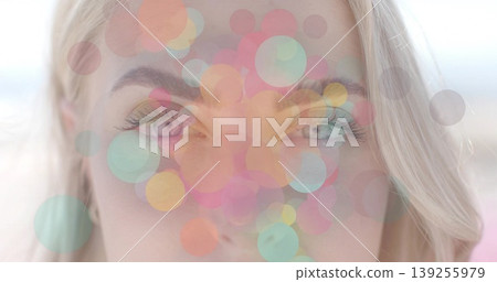 Displaying adult female face featuring translucent pastel circle overlays in studio, bokeh effect Displaying adult female face featuring translucent pastel circle overlays in studio, bokeh effect 139255979
