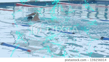Swimming male with swim cap, goggles propelling through water at aquatic center, with lane dividers Swimming male with swim cap, goggles propelling through water at aquatic center, with lane dividers 139256014