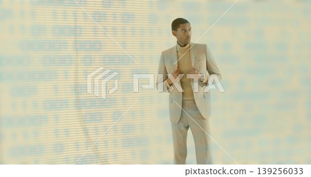 Standing man wearing tan suit and camel turtleneck, checking silver watch in studio, binary overlay Standing man wearing tan suit and camel turtleneck, checking silver watch in studio, binary overlay 139256033