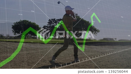 Swinging senior golfer wearing cap and polo in sand bunker, with grid and line chart overlay 139256044