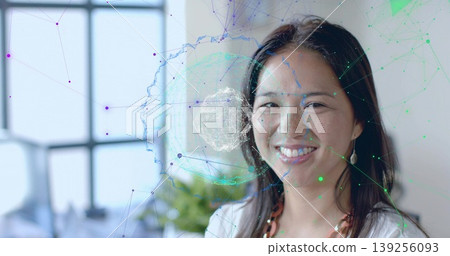 Standing professional in white blouse at office window, showing network overlay, plant, copy space Standing professional in white blouse at office window, showing network overlay, plant, copy space 139256093