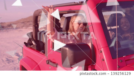Two friends driving pink Jeep in sandy dune under sunset glow, wearing sunglasses Two friends driving pink Jeep in sandy dune under sunset glow, wearing sunglasses 139256129