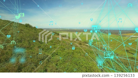 Displaying cyan connectivity mesh overlaying hillside and farmland, with floating network icons Displaying cyan connectivity mesh overlaying hillside and farmland, with floating network icons 139256133