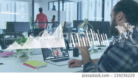 Gesturing male office worker using laptop in open plan office with graphs overlay, copy space Gesturing male office worker using laptop in open plan office with graphs overlay, copy space 139256220