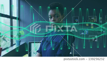 Reviewing charts tech professional woman wearing blue blouse at desk in office, with waveforms Reviewing charts tech professional woman wearing blue blouse at desk in office, with waveforms 139256232
