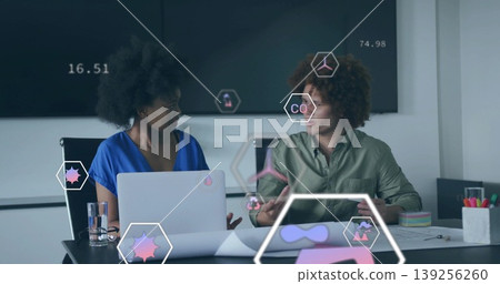 Collaborating coworkers wearing business attire analyzing data in meeting room, with laptop, screen Collaborating coworkers wearing business attire analyzing data in meeting room, with laptop, screen 139256260