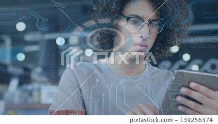 Holding smartphone and typing code in coworking space, with coffee mug and data-driven overlay 139256374