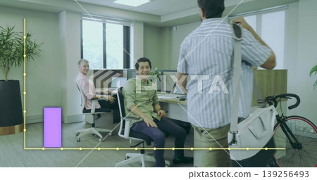 Smiling Asian Indian man in green shirt sitting at desk in office, with bicycle, chart overlay 139256493