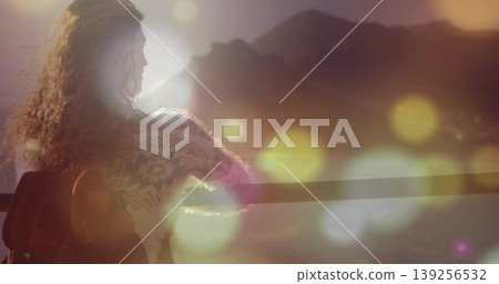 Leaning on railing, woman in sweater observing sunrise at mountain vista, with backpack, copy space Leaning on railing, woman in sweater observing sunrise at mountain vista, with backpack, copy space 139256532