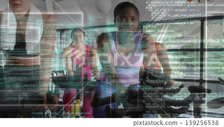 Black woman wearing lavender top, black shorts, cycling on exercise bikes in gym with code overlay Black woman wearing lavender top, black shorts, cycling on exercise bikes in gym with code overlay 139256538
