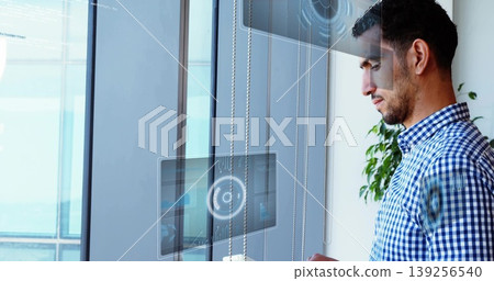 Interacting mid adult man using holographic panels by office windows with skyline, copy space Interacting mid adult man using holographic panels by office windows with skyline, copy space 139256540