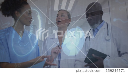 Pointing scrub nurse and labcoat doctors analyzing digital display in ward with tablet stethoscope Pointing scrub nurse and labcoat doctors analyzing digital display in ward with tablet stethoscope 139256571