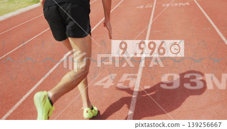 Athlete running in black shorts, green shoes on red track, displaying stopwatch waveform at 9 Athlete running in black shorts, green shoes on red track, displaying stopwatch waveform at 9 139256667