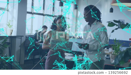 Collaborating professionals using laptop and smartphone at office, network graphics overlay Collaborating professionals using laptop and smartphone at office, network graphics overlay 139256692