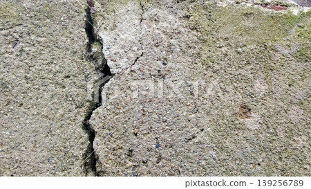 Cracked Concrete Wall with Moss Texture Shows Urban Weathering and Rough Surface Cracked Concrete Wall with Moss Texture Shows Urban Weathering and Rough Surface 139256789