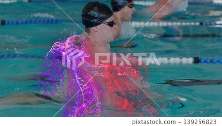 Cutting lead swimmer with black cap and tinted goggles breaststroking in pool with particle effect Cutting lead swimmer with black cap and tinted goggles breaststroking in pool with particle effect 139256823