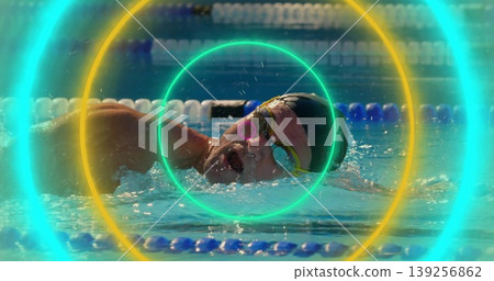 Swimming athlete freestyling with black swim cap, goggles in lap pool with dividers and rings Swimming athlete freestyling with black swim cap, goggles in lap pool with dividers and rings 139256862
