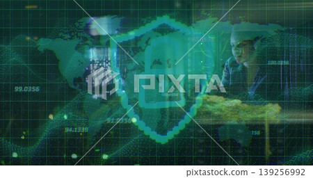 Woman reviewing cybersecurity data in dimly lit office, with glowing teal shield icon overlay Woman reviewing cybersecurity data in dimly lit office, with glowing teal shield icon overlay 139256992