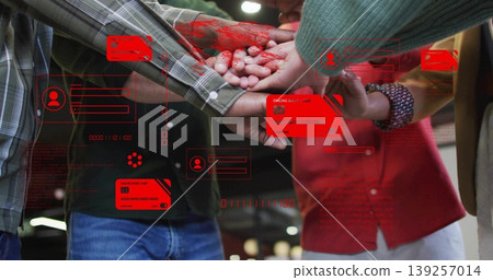 Joining colleagues placing hands in open-plan office, with red credit-card icons and code overlays 139257014
