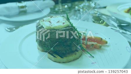 Showcasing seared steak on bread round on plate at dining table, with baby carrots and salicornia Showcasing seared steak on bread round on plate at dining table, with baby carrots and salicornia 139257043
