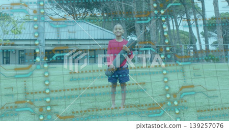 Standing barefoot boy wearing red shirt holding green rugby ball on sports field, circuit overlay Standing barefoot boy wearing red shirt holding green rugby ball on sports field, circuit overlay 139257076