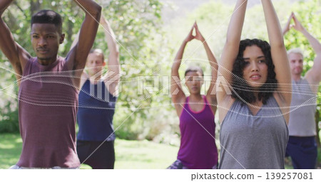 Stretching six yoga practitioners in activewear raising arms overhead on park lawn, with yoga mats Stretching six yoga practitioners in activewear raising arms overhead on park lawn, with yoga mats 139257081