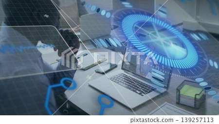Interacting woman at laptop projecting holographic overlay at office desk, with notebook and mug Interacting woman at laptop projecting holographic overlay at office desk, with notebook and mug 139257113