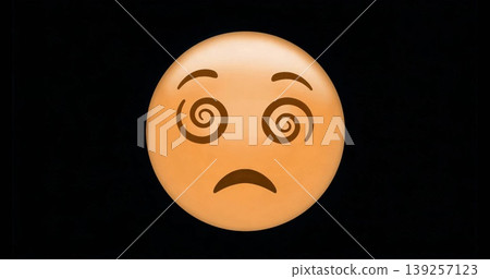 Displaying yellow-orange emoji face with spiraling eyes on black background, expressing confusion 139257123