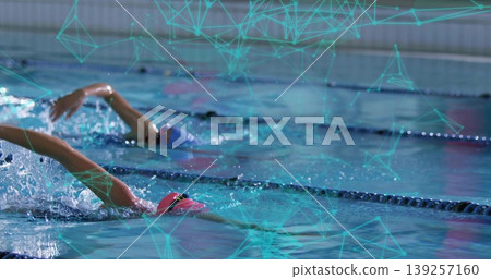Racing swimmers in pink, blue one piece swimsuits and goggles pushing through pool lanes with ropes Racing swimmers in pink, blue one piece swimsuits and goggles pushing through pool lanes with ropes 139257160