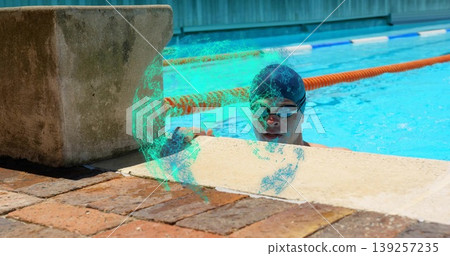Swimmer wearing cap holding pool edge at outdoor pool wall, with starting block and lane divider Swimmer wearing cap holding pool edge at outdoor pool wall, with starting block and lane divider 139257235