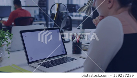 Leaning woman resting chin on hand at open office desk, with laptop corner guides, copy space Leaning woman resting chin on hand at open office desk, with laptop corner guides, copy space 139257259